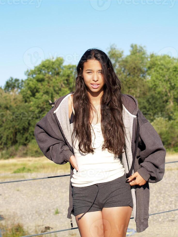 joven mezclado marrón niña al aire libre en pantalones cortos foto