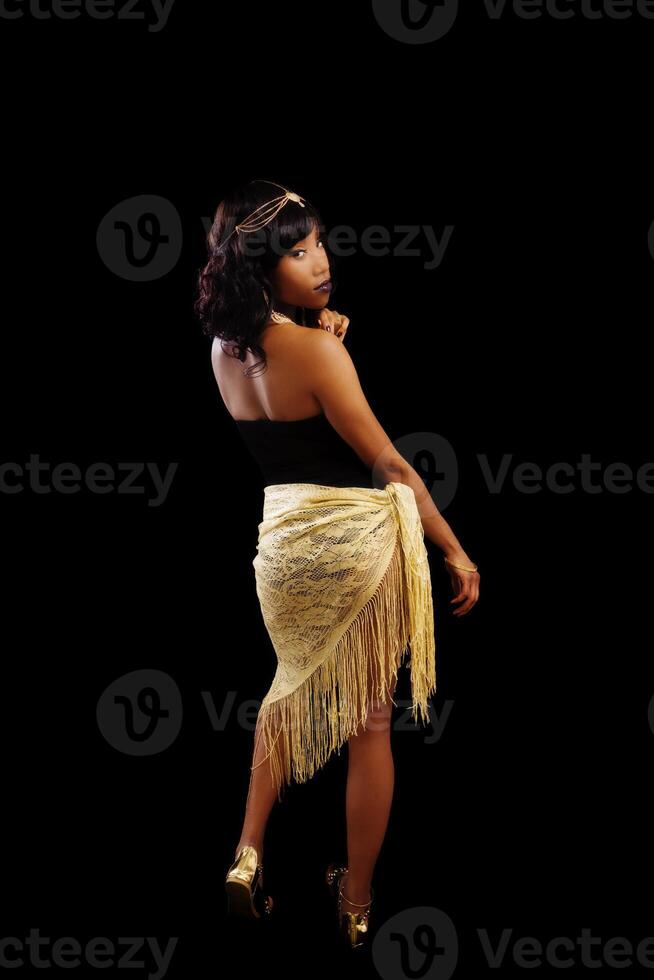 africano americano mujer en pie negro y oro atuendo foto