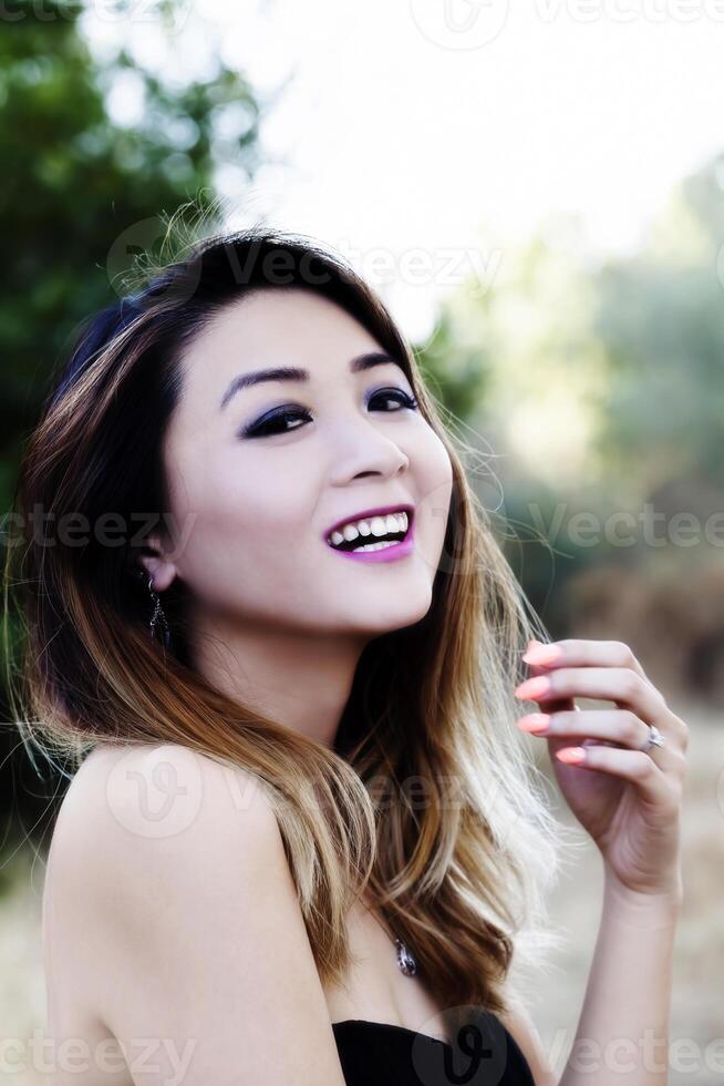 asiático americano mujer al aire libre en desnudo hombro vestir sonriente foto