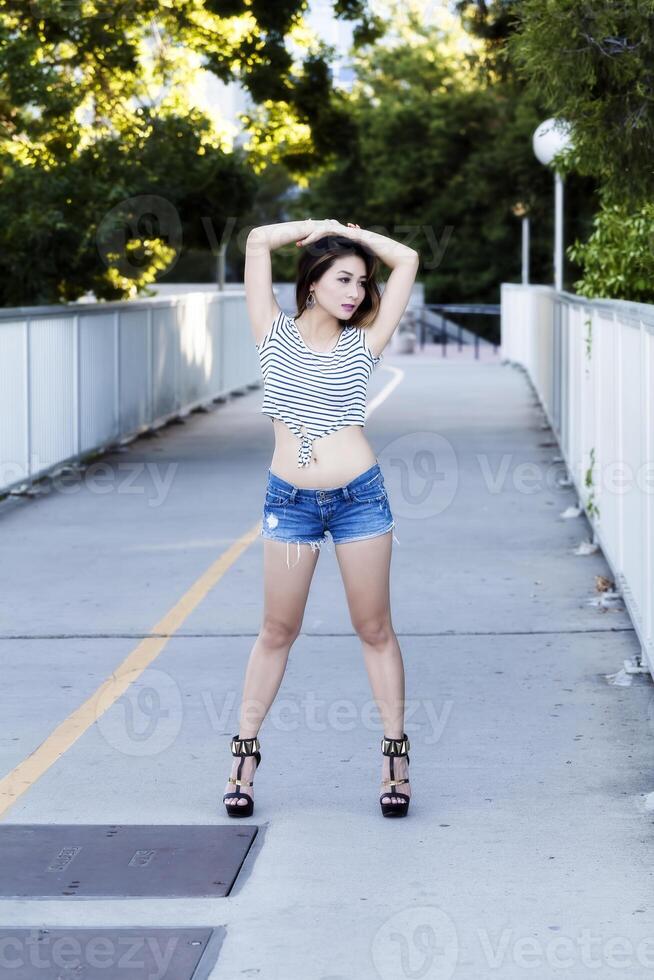 Asian American Woman Standing Outdoors In Jeans Shorts photo