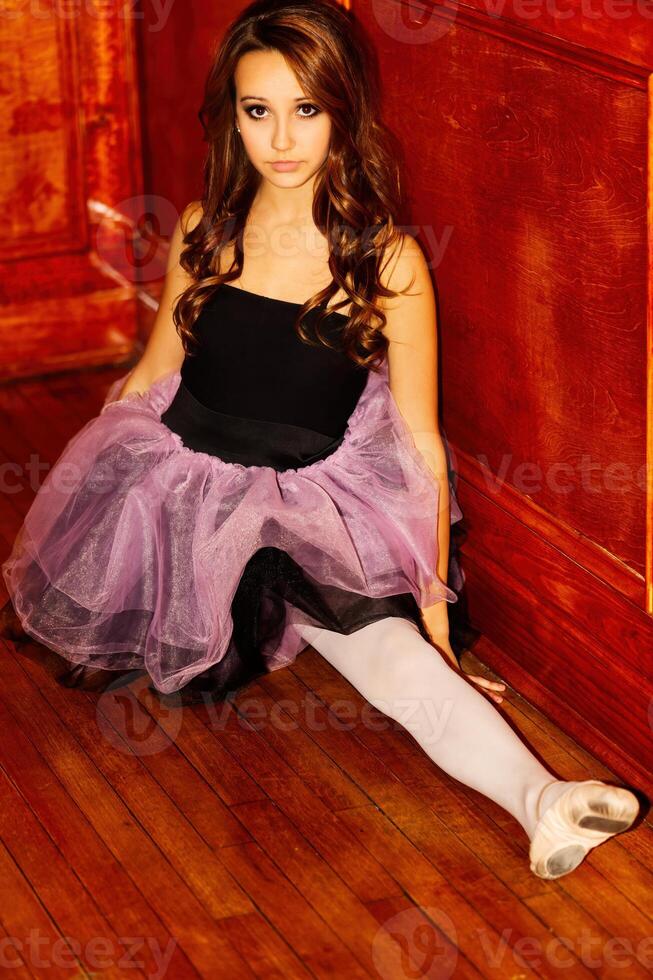 Young Caucasian Teen In Dance Outfit Sitting On Wooden Floor photo