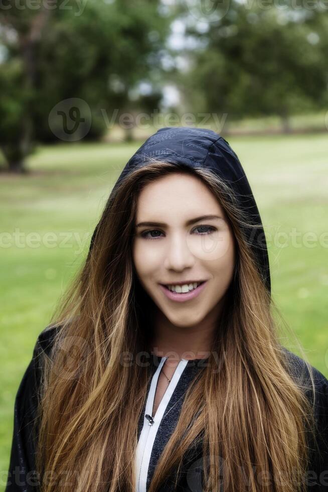 caucásico adolescente niña al aire libre retrato en negro capucha chaqueta foto