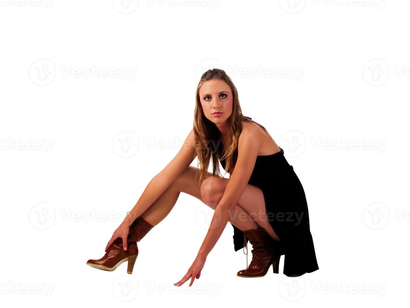 Young Caucasian Woman Squating Down In Black Dress And Boots photo