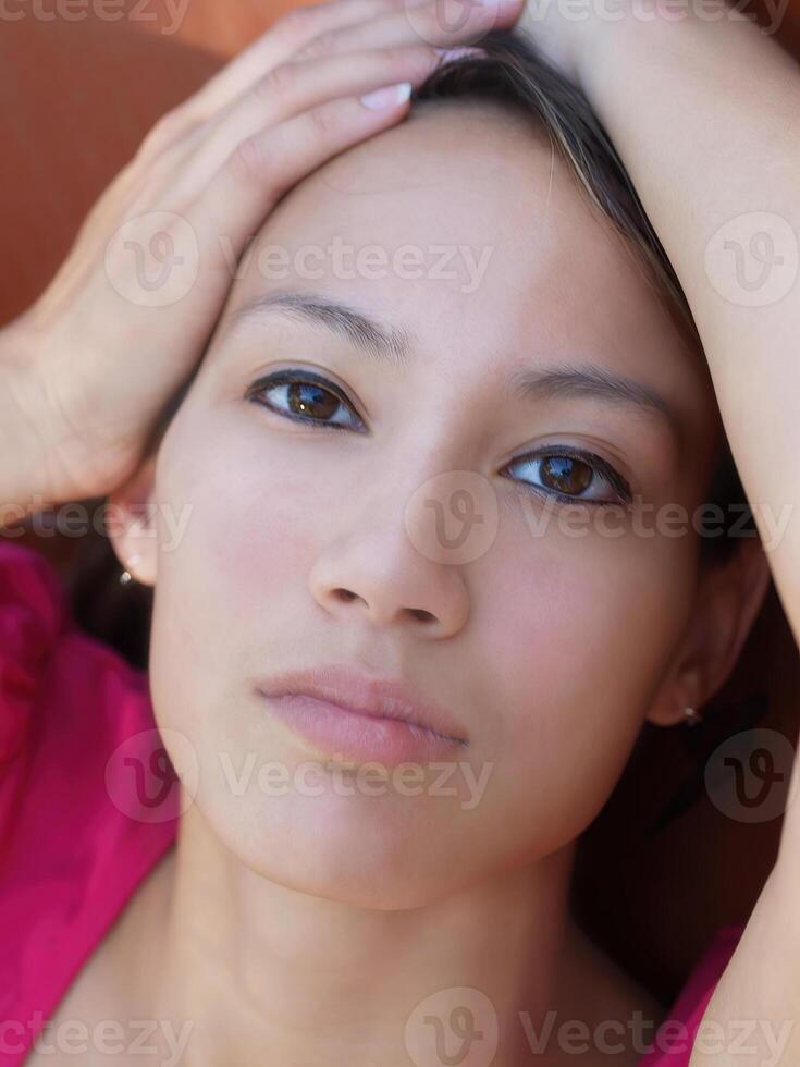 Tight Portrait Of Asian American Woman With Hands On Head photo