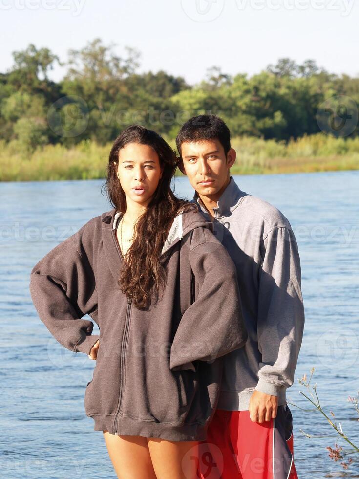 Man And Woman Standing At River In Bright Sunlight photo