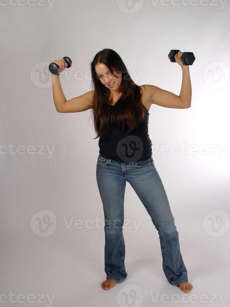 Young Caucasian Woman with Weights In Blue Jeans And Top photo