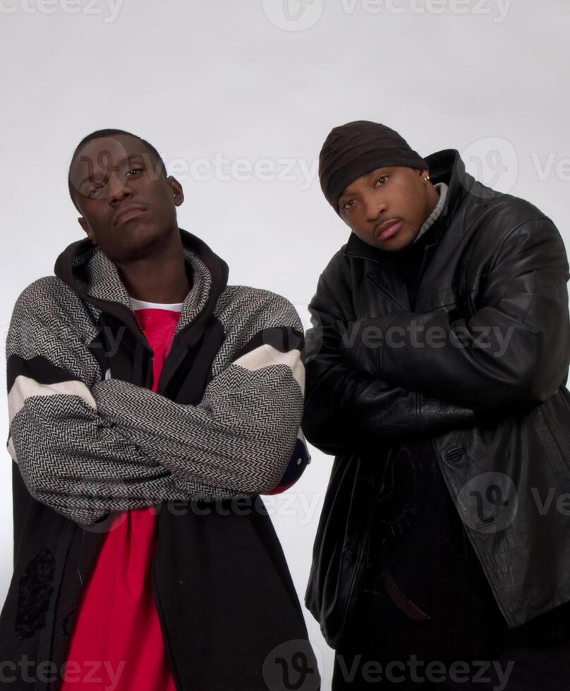 dos africano americano hombres en chaquetas con brazos cruzado foto