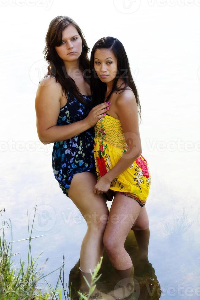 Caucasian And Asian American Women Standing In River photo