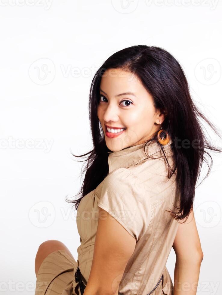 Young Hispanic Woman In Brown Dress Looking Back Over Shoulder photo