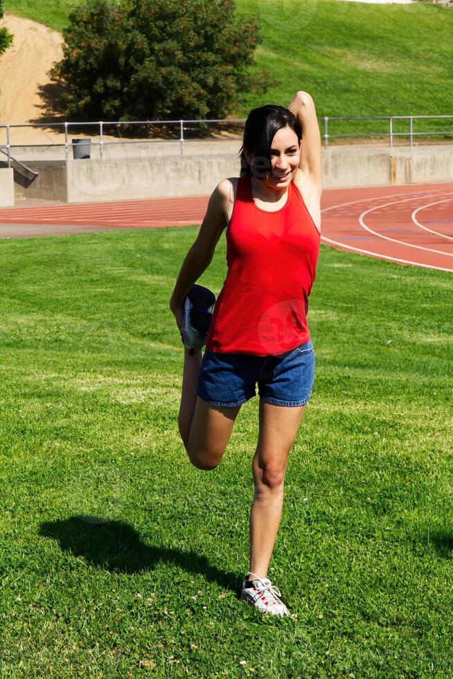 Young Hispanic Teen Girl Stretching At Track photo