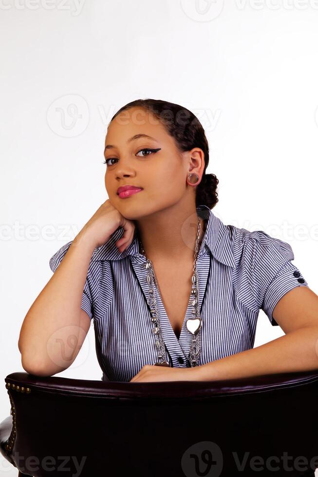 Young Attractive Mixed Woman Sitting With Arms On Back Of Chair photo