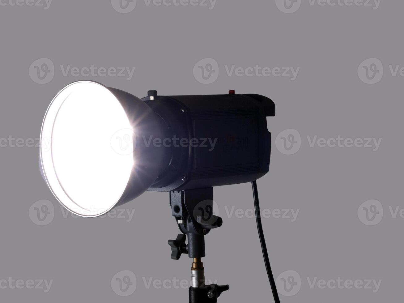 Studio monolight flash unit firing against gray background photo