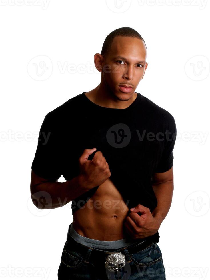 Young black man holding up shirt in jeans photo
