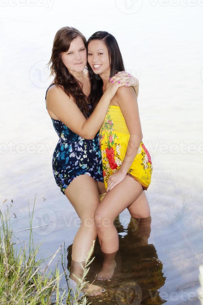 Two Women Standing In Water With Dresses photo