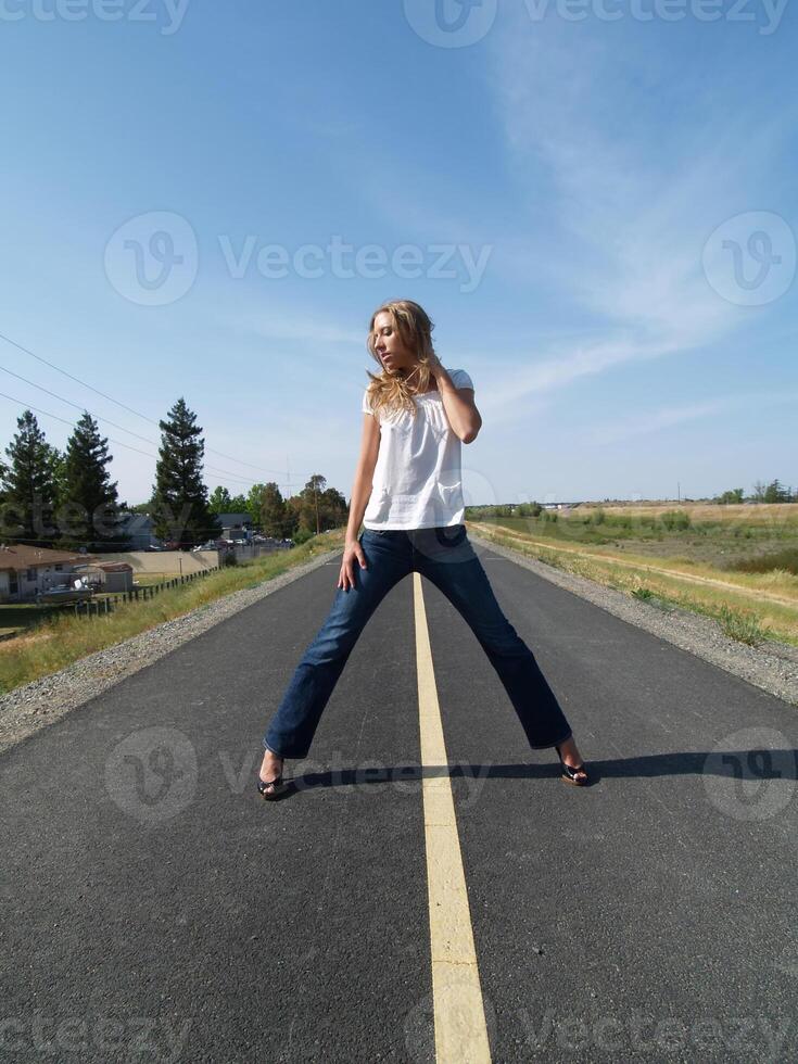 Young blond woman on bike path in jeans photo