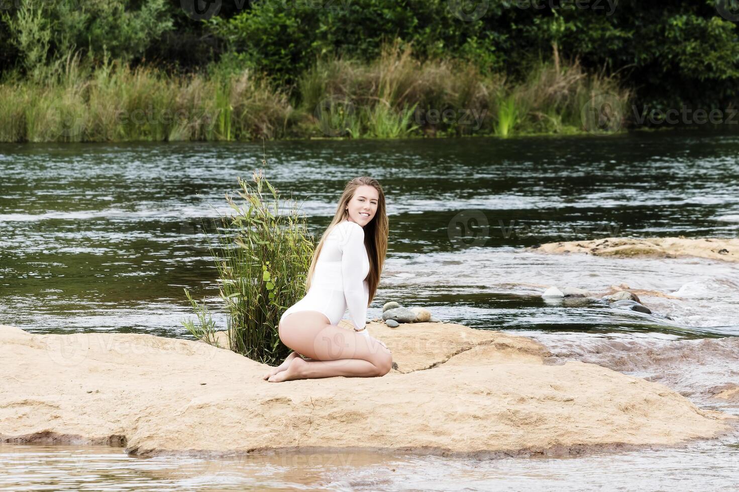 caucásico adolescente mujer sentado en suciedad en río blanco leotardo foto