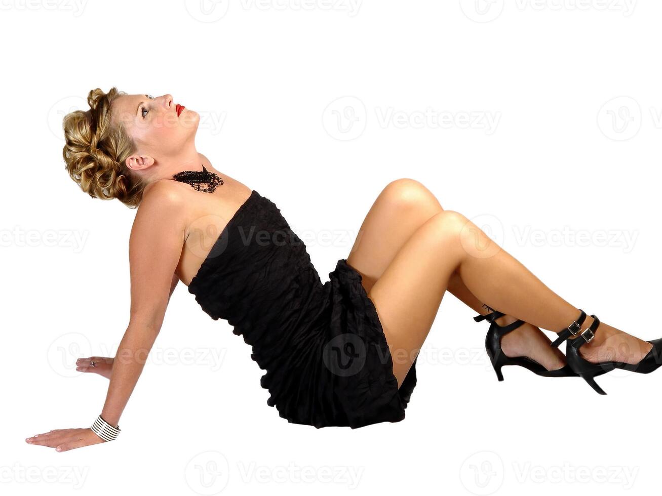 Young Caucasian Woman In Black Dress Sitting On White Background photo