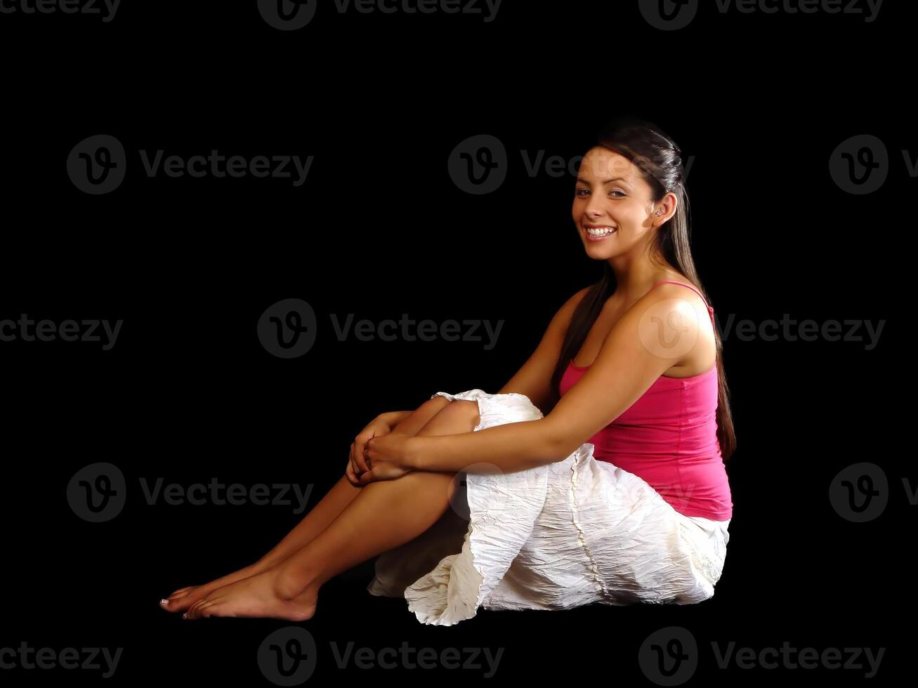 sonriente caucásico mujer sentado en blanco falda y rojo parte superior foto