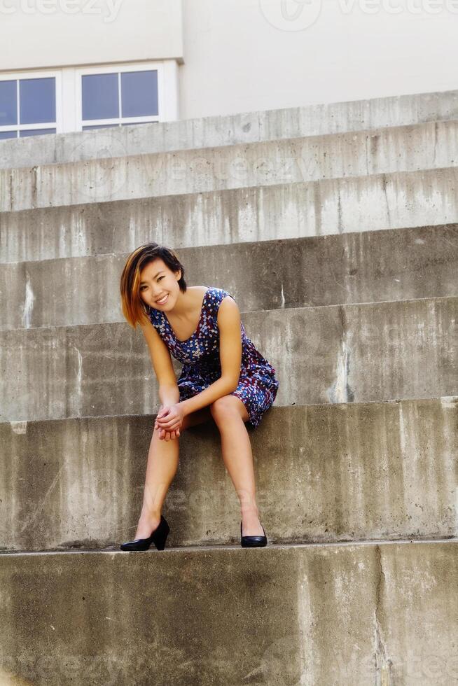 Smiling Attractive Asian American Woman Sitting On Steps photo