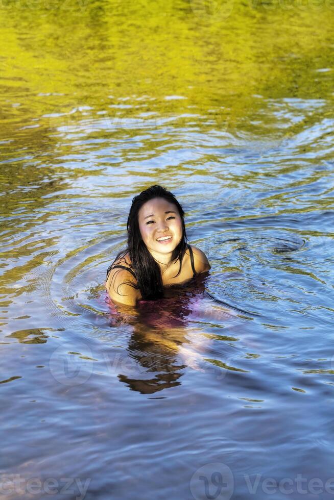 Young Japanese Woman Sitting River Dress Smiling photo