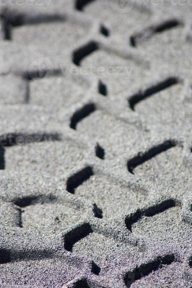 Deep Tire Tread Tracks In Sand Close-up photo