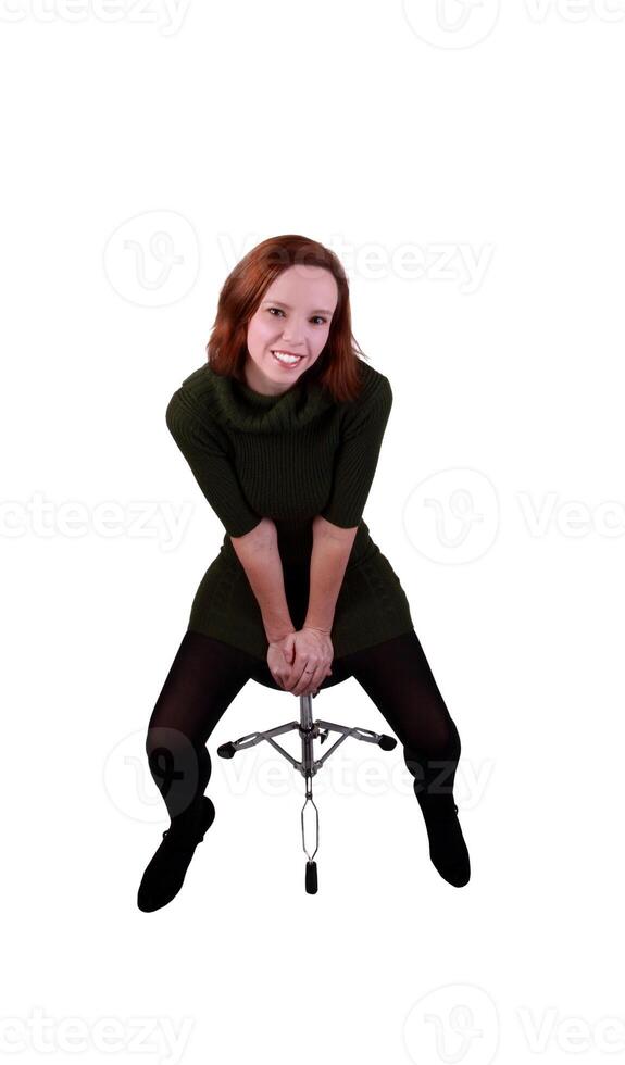 redheaded woman sitting on stool leaning forward photo