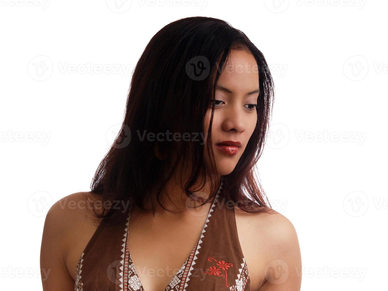 Young hispanic woman in brown dress looking down photo