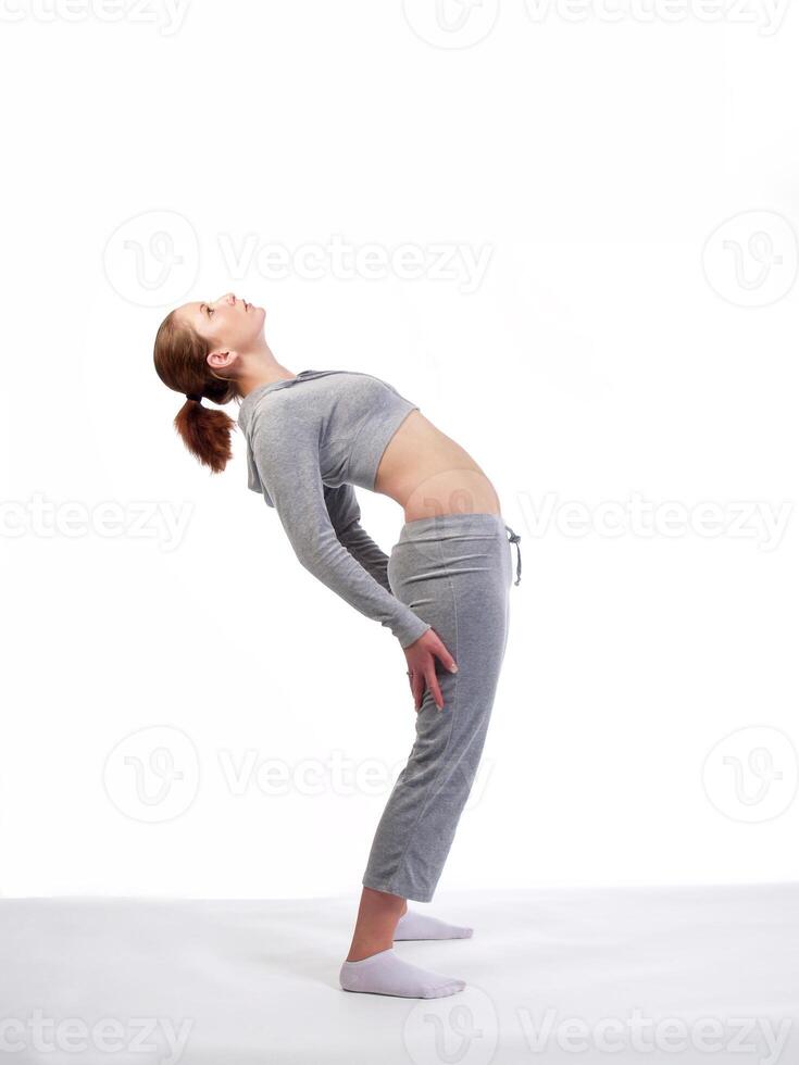 Young Caucasian Woman Back Stretch In Gray Sweat Suit photo