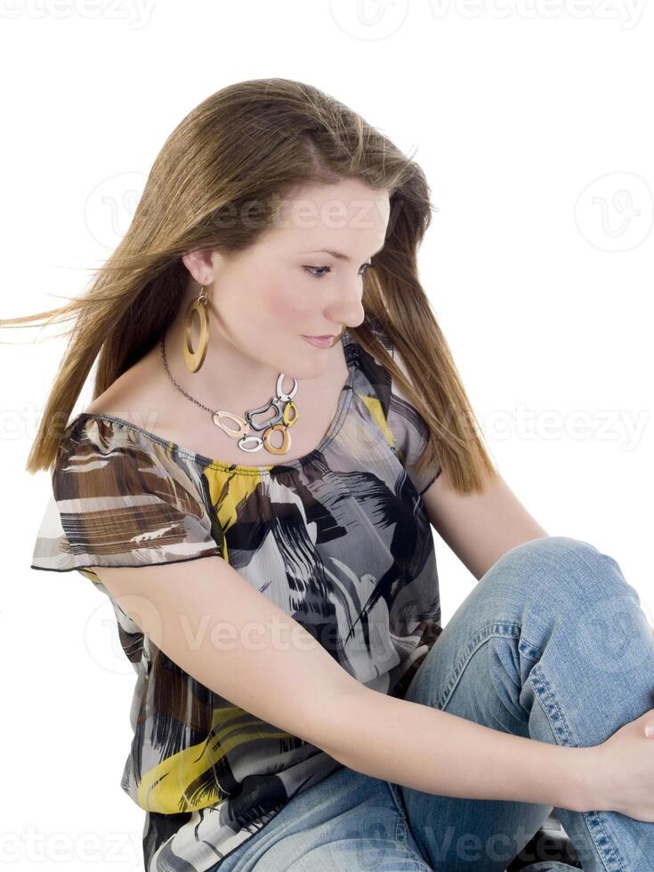 joven mujer sentado en piso en pantalones y blusa foto
