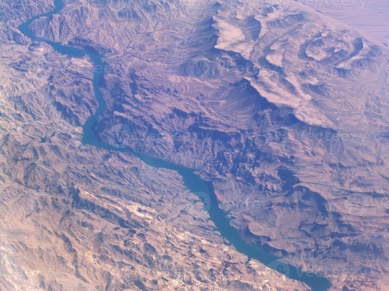 Aerial Shot Of River Winding Through Barren Hills photo