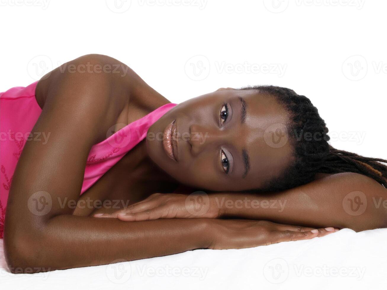 Young black woman reclining in pink dress photo