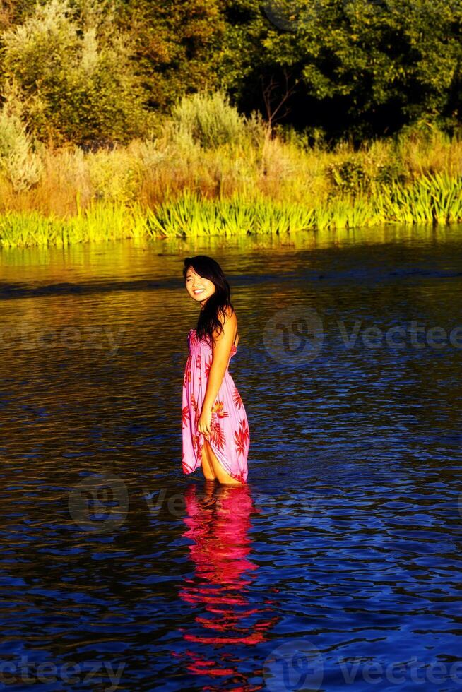 sonriente oriental joven mujer río vestir al aire libre foto