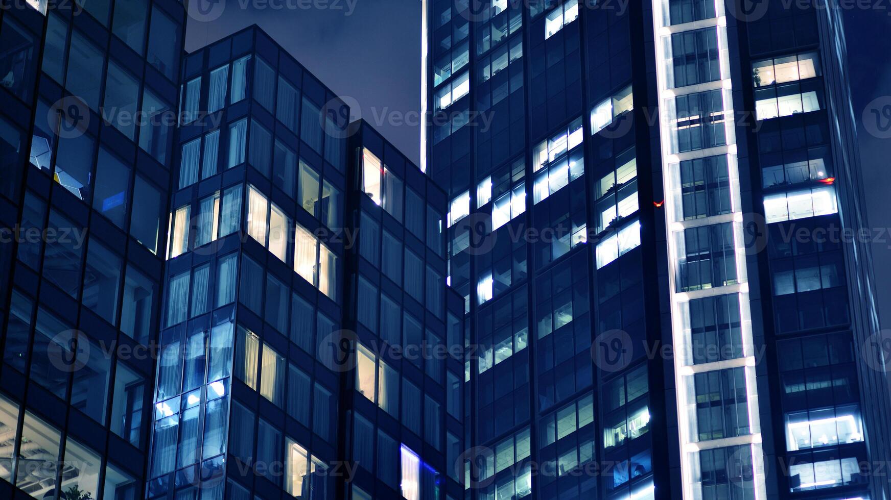 Office buildings by night. Night architectural, buildings with glass facade. Modern buildings in business district. Concept of economics, financial. photo