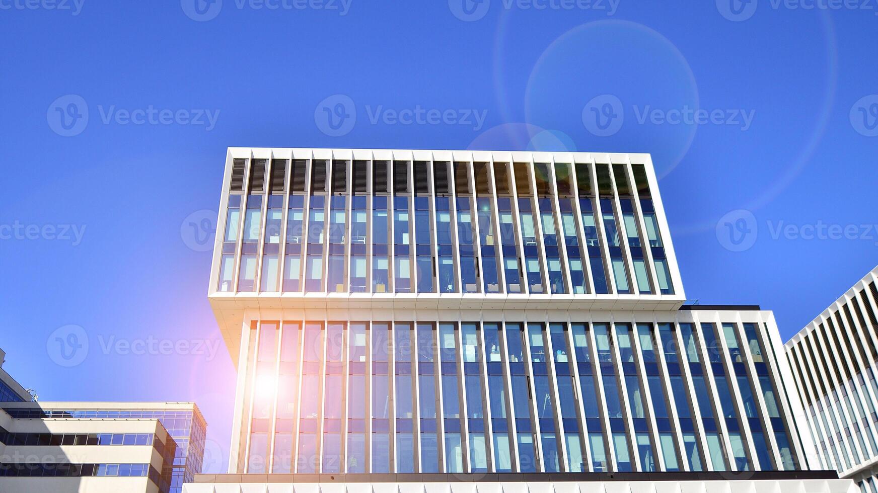 Modern office building in the city with windows and steel and aluminum panels wall. Contemporary commercial architecture, vertical converging geometric lines. photo