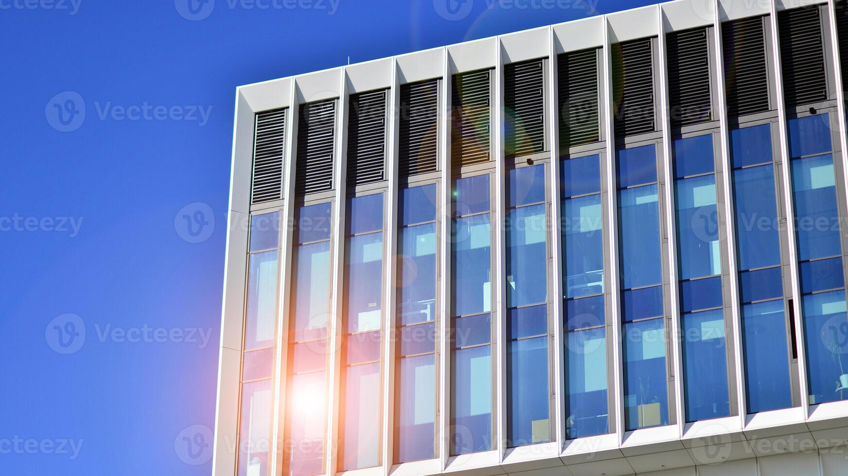 Modern office building in the city with windows and steel and aluminum panels wall. Contemporary commercial architecture, vertical converging geometric lines. photo