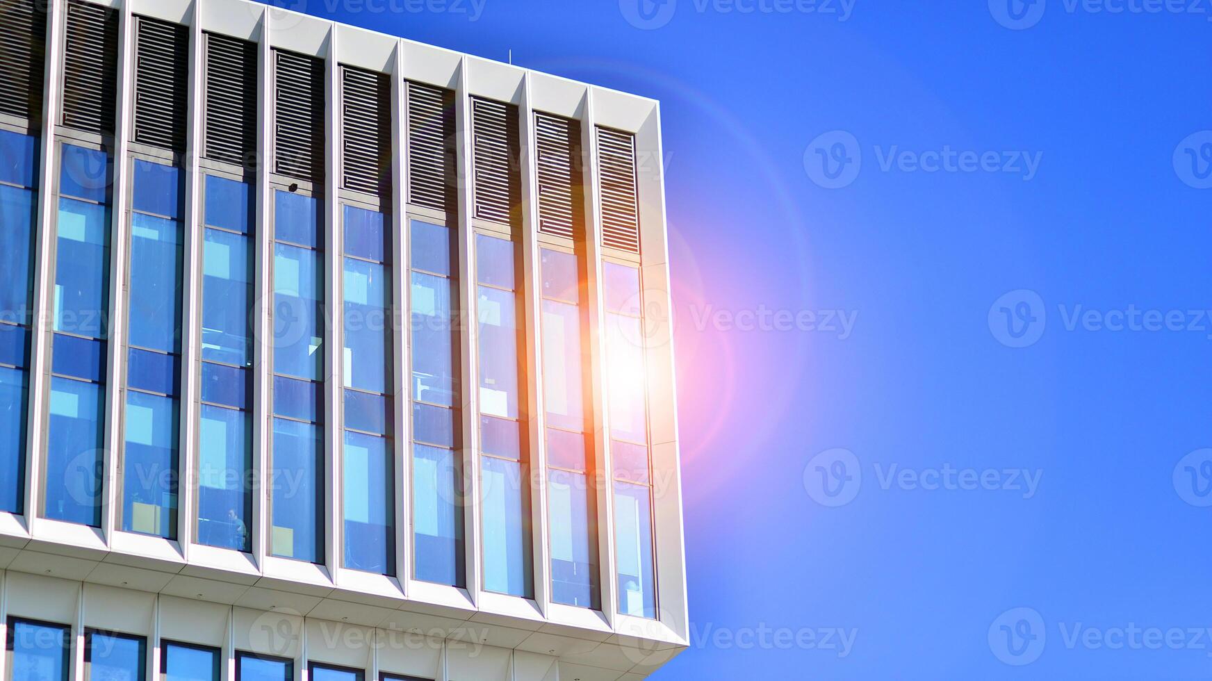 Modern office building in the city with windows and steel and aluminum panels wall. Contemporary commercial architecture, vertical converging geometric lines. photo