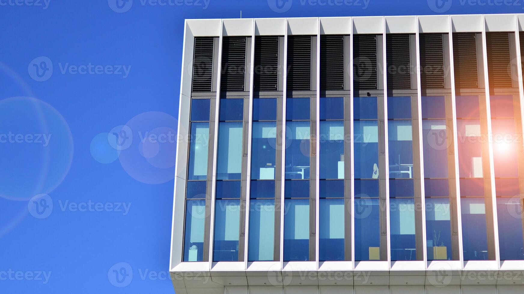 Modern office building in the city with windows and steel and aluminum panels wall. Contemporary commercial architecture, vertical converging geometric lines. photo