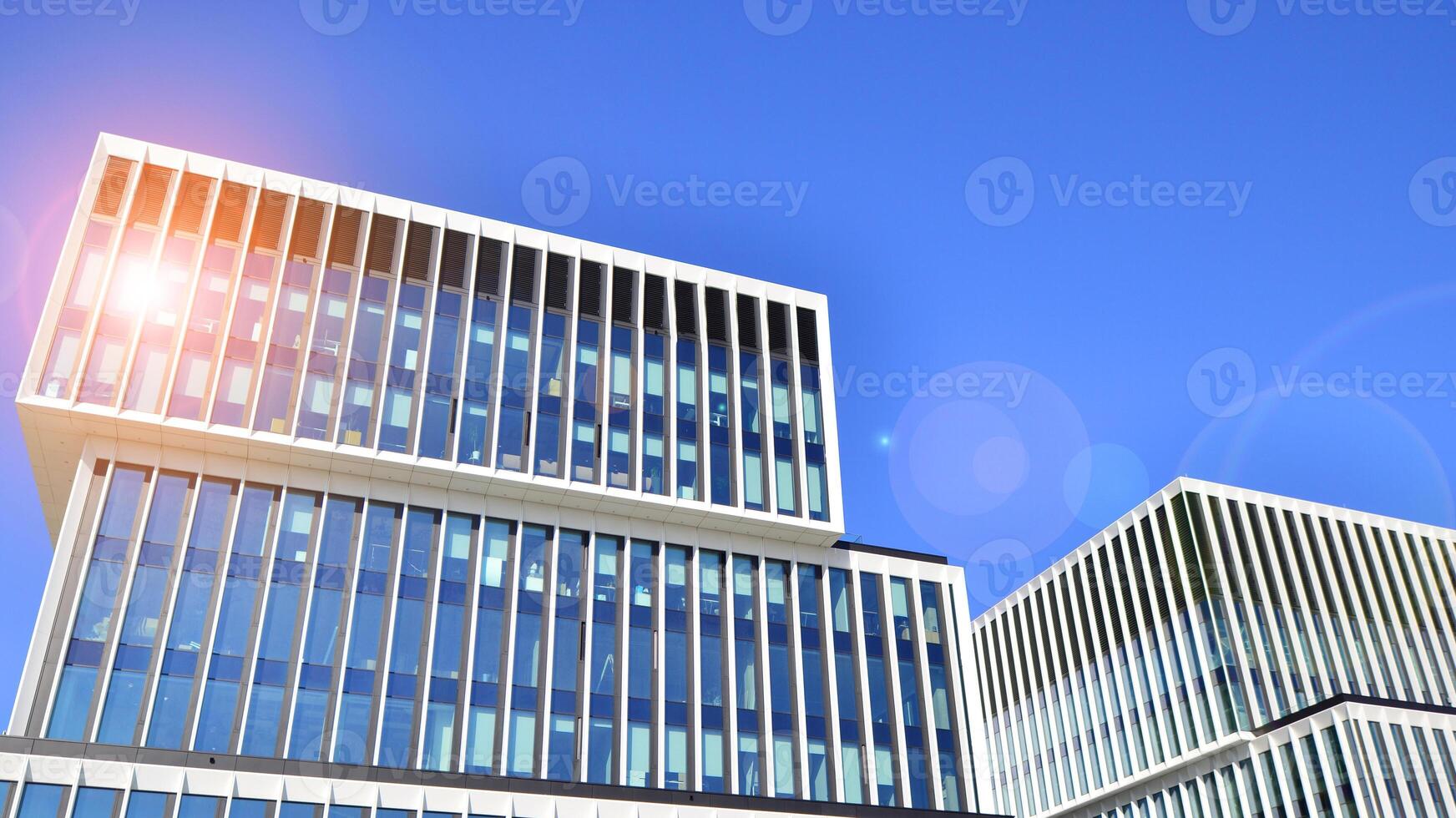 Modern office building in the city with windows and steel and aluminum panels wall. Contemporary commercial architecture, vertical converging geometric lines. photo