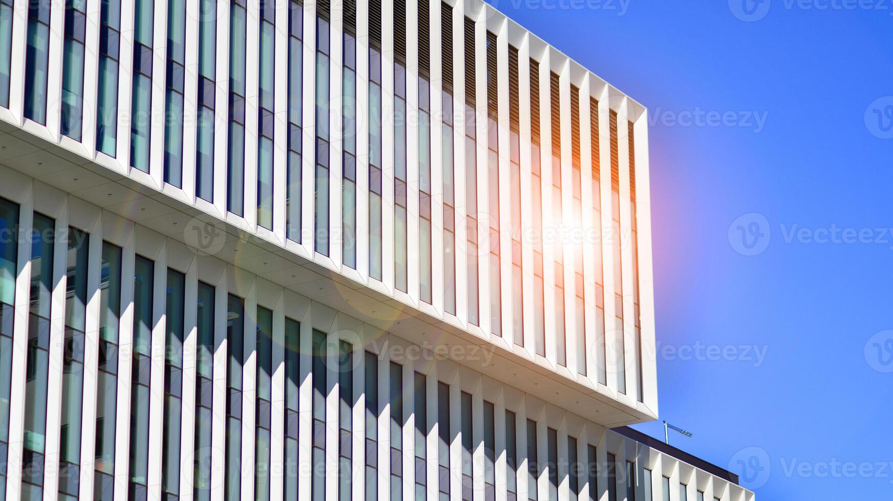 Modern office building in the city with windows and steel and aluminum panels wall. Contemporary commercial architecture, vertical converging geometric lines. photo
