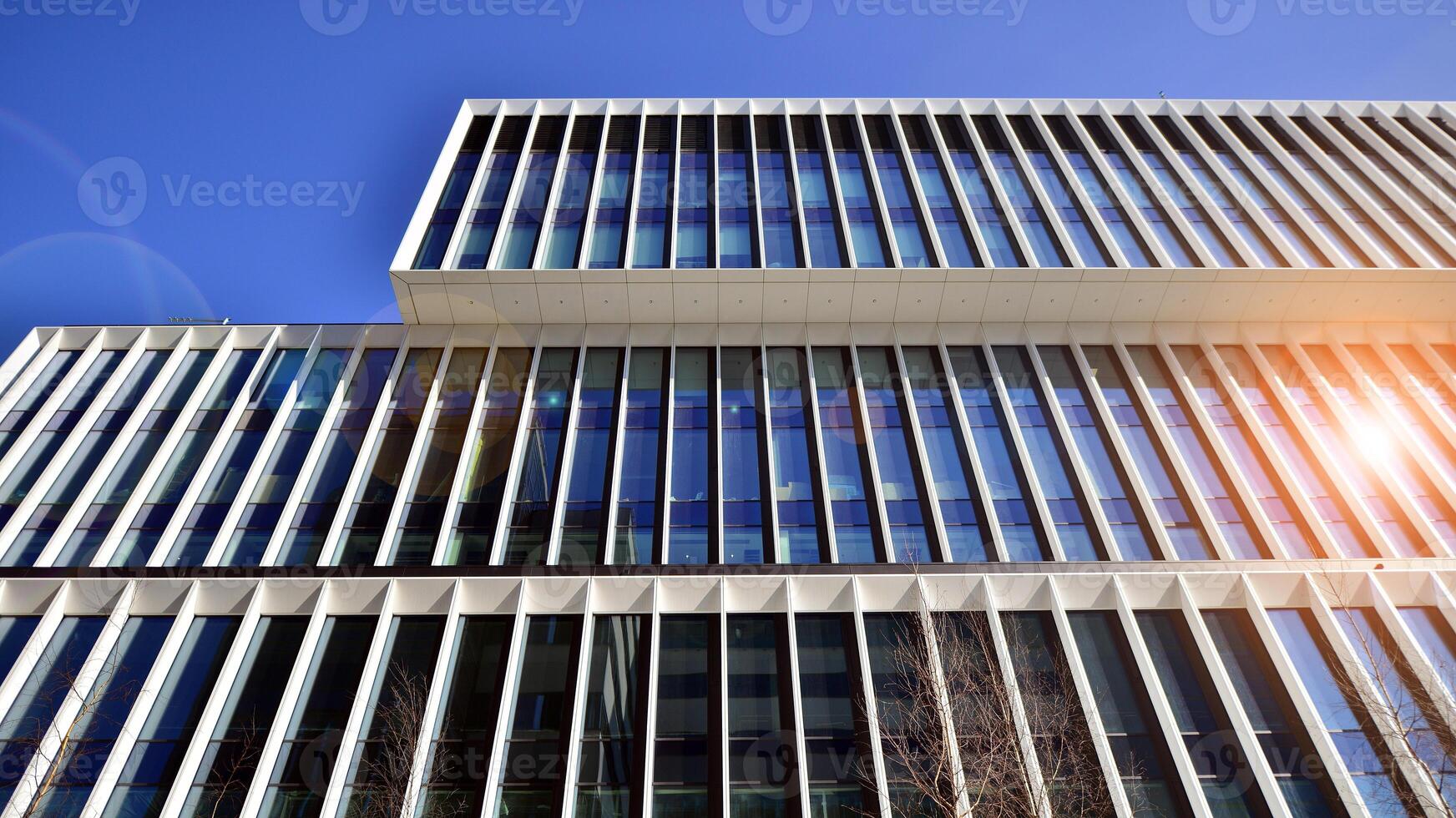 Modern office building in the city with windows and steel and aluminum panels wall. Contemporary commercial architecture, vertical converging geometric lines. photo