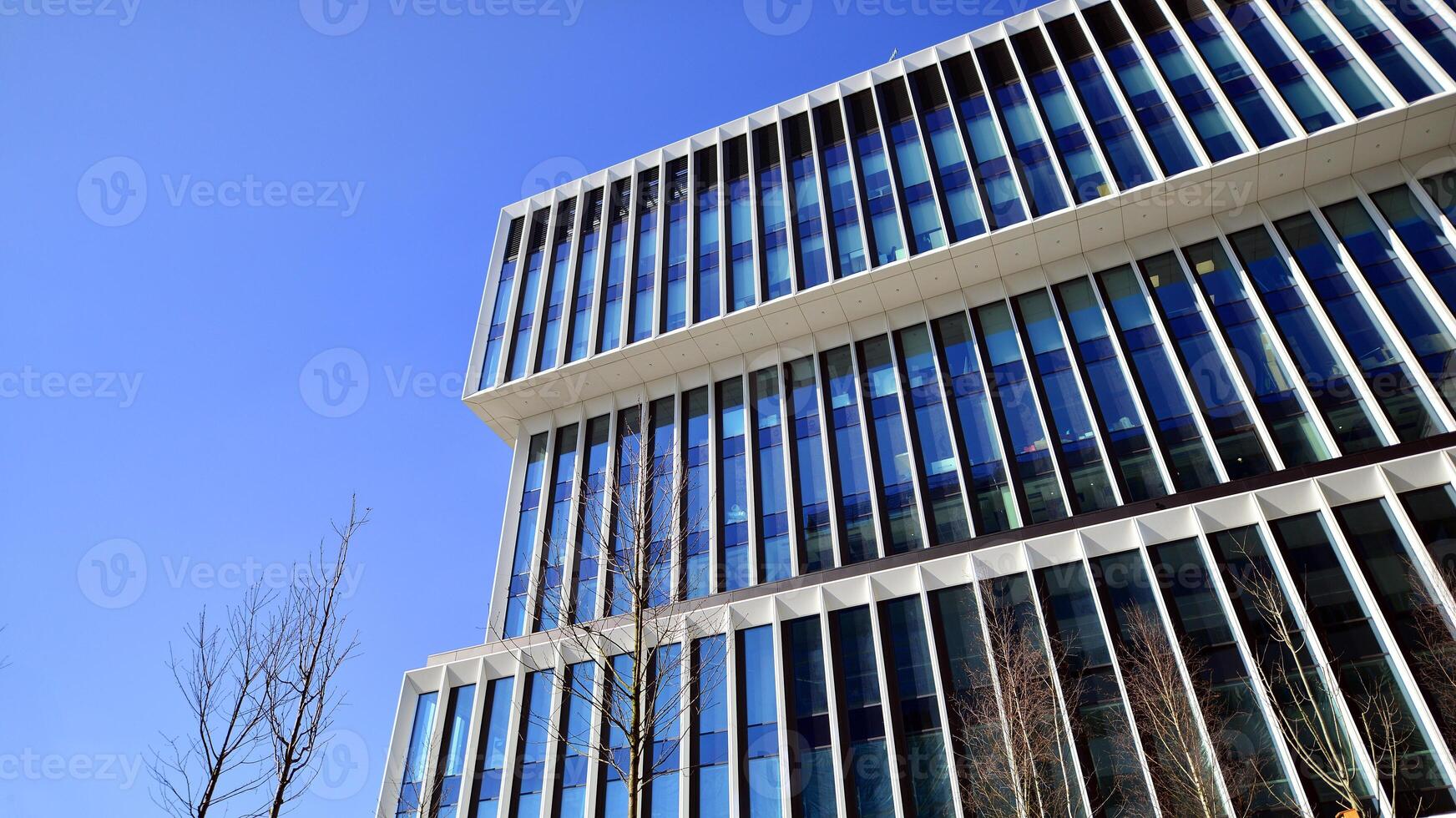 Modern office building in the city with windows and steel and aluminum panels wall. Contemporary commercial architecture, vertical converging geometric lines. photo