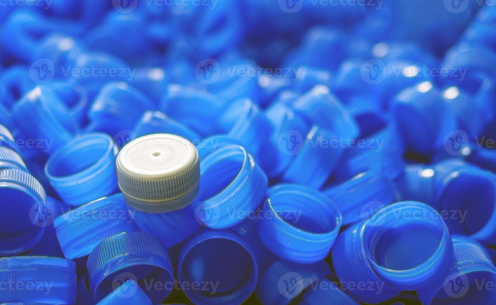 Grey plastic bottle caps on top to depict the concept of standing out from the crowd, dare to be different, odd man out, success or a leadership concept. photo