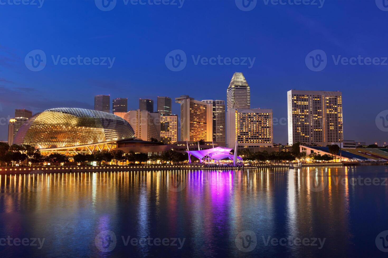 Singapore skyline skyscrapers over Marina Bay illuminated in evening photo