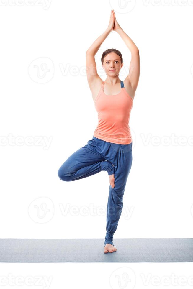 Woman practices yoga asana Vrikshasana tree po photo