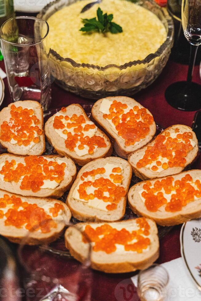 hecho en casa festivo almuerzo con sándwiches, rojo caviar, y mantequilla en mesa foto