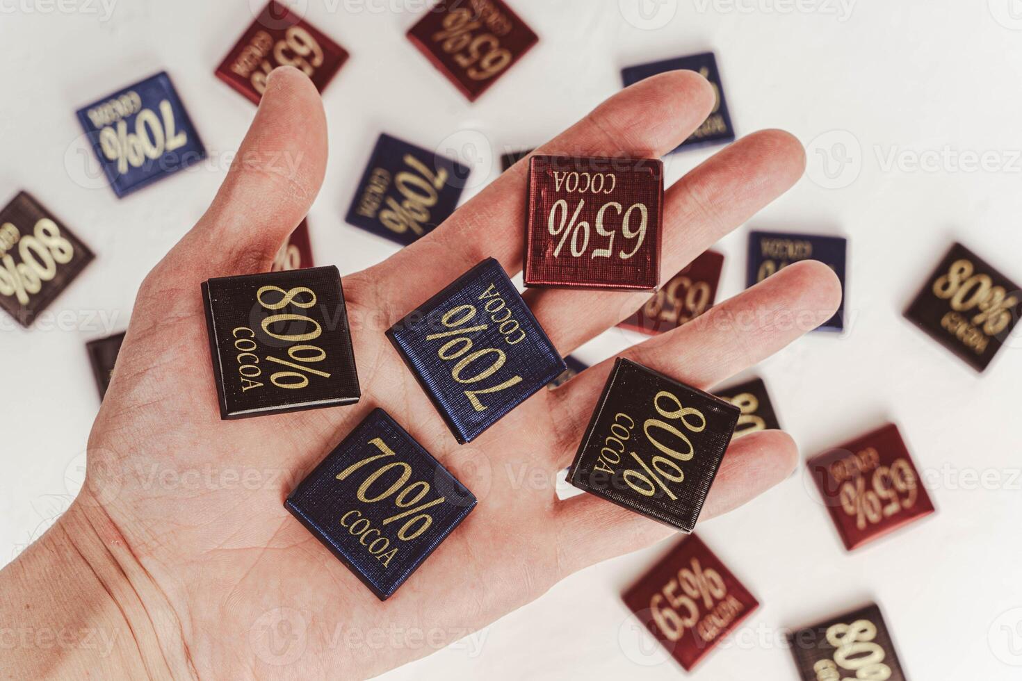 man holding box of chocolate bars with 65, 70, and 80 percent cocoa content photo