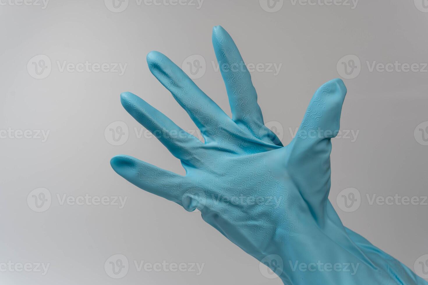 Close-up of hand in rubber glove with splayed fingers for medical or cleaning concept photo