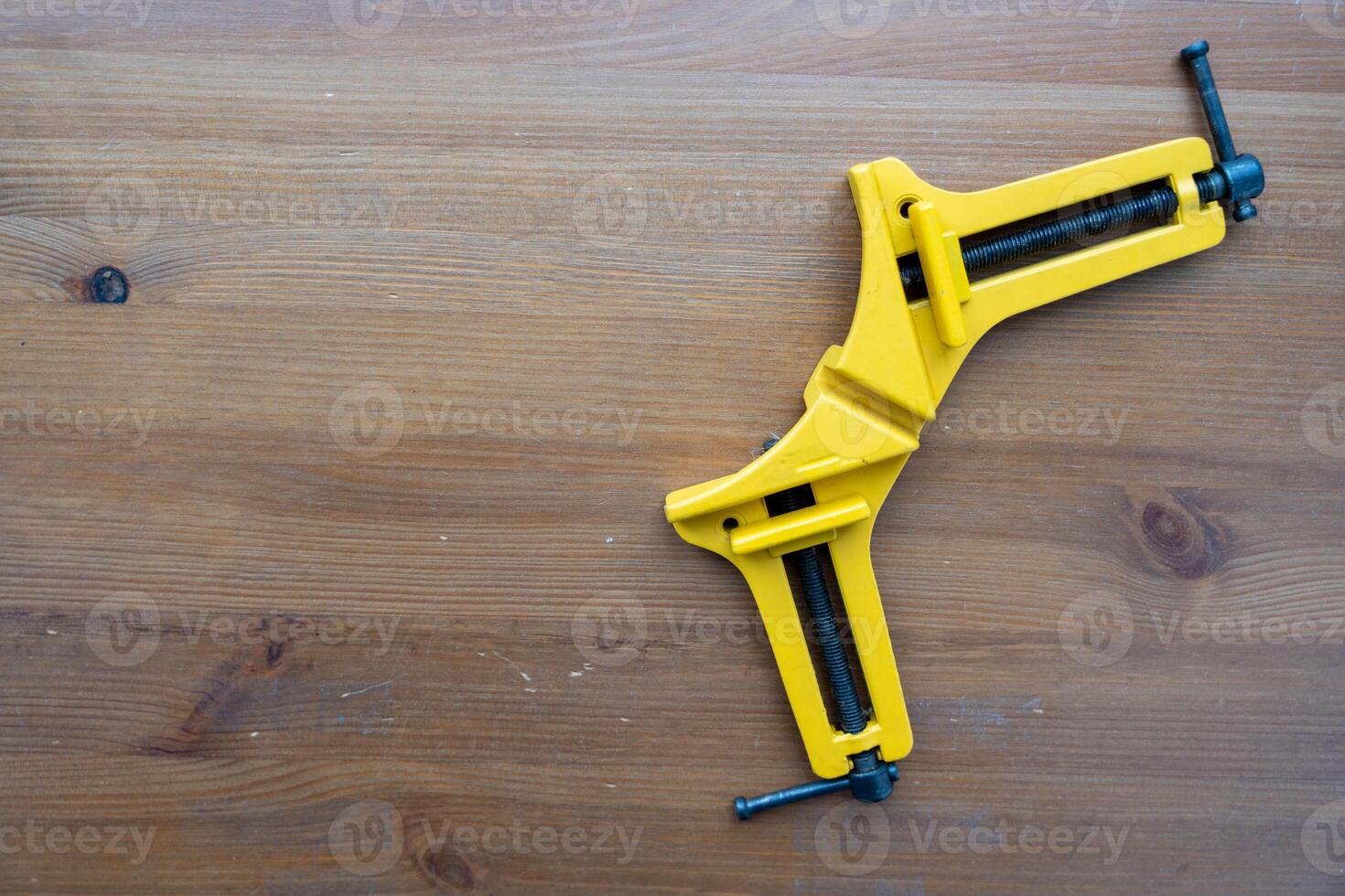 Pair of Yellow Clamps on Wooden Table photo