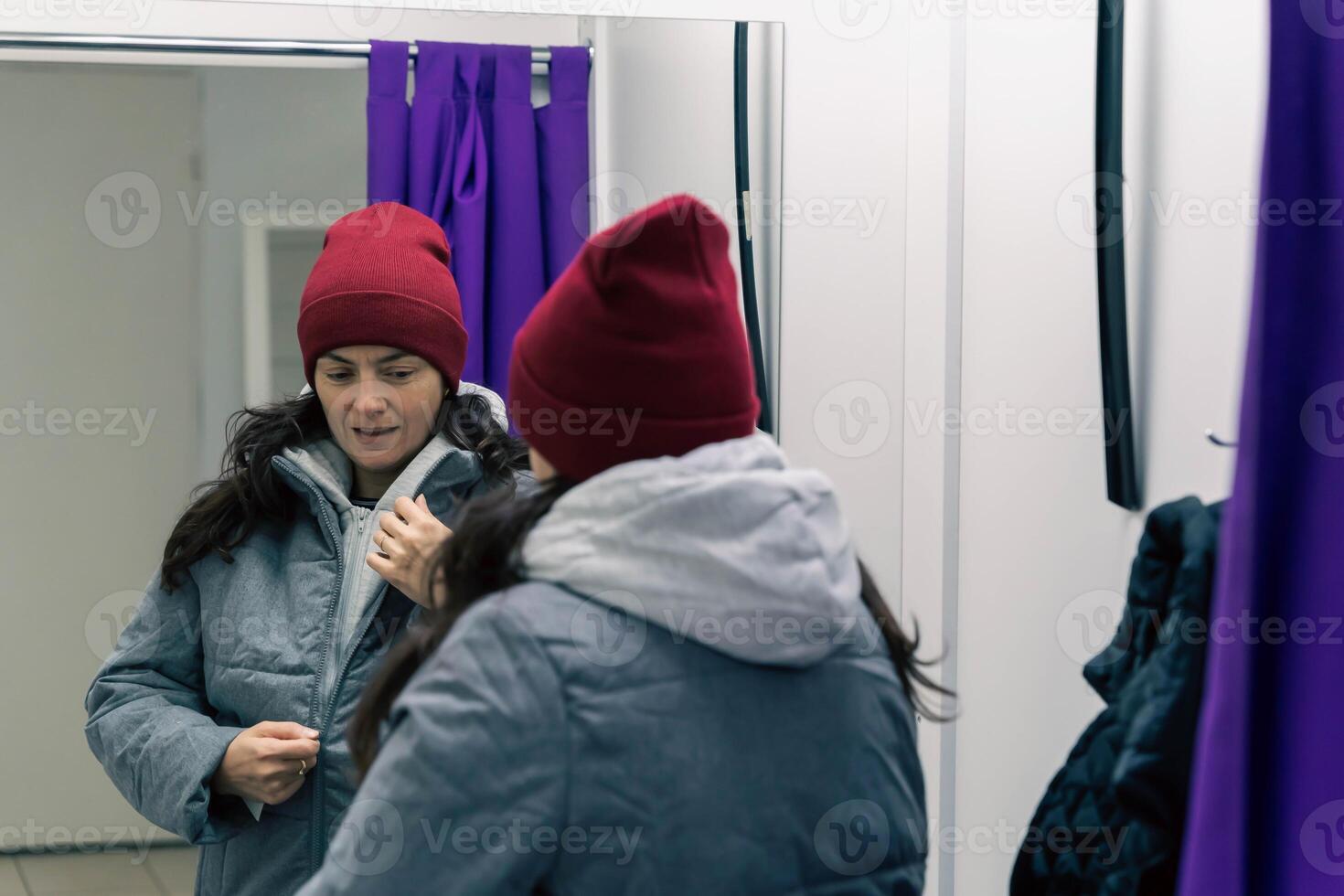 mujer en medio años molesto en chaqueta y sombrero en adecuado habitación a recoger punto foto