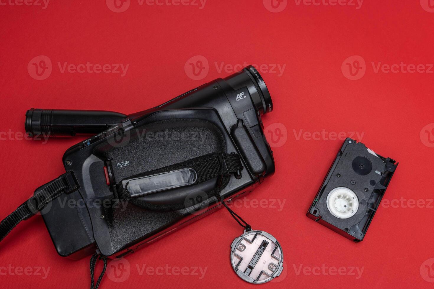 Vintage VHS video camera and a cassette on a red background. retro, 90s photo